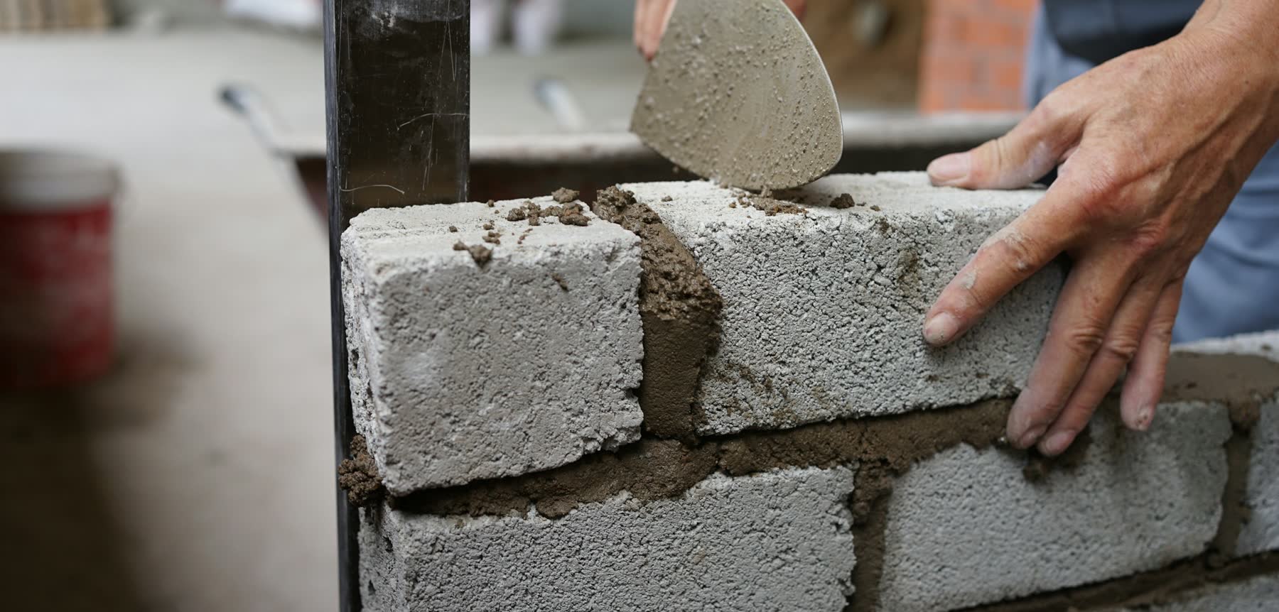 Bricklayer laying blockwork with a trowel