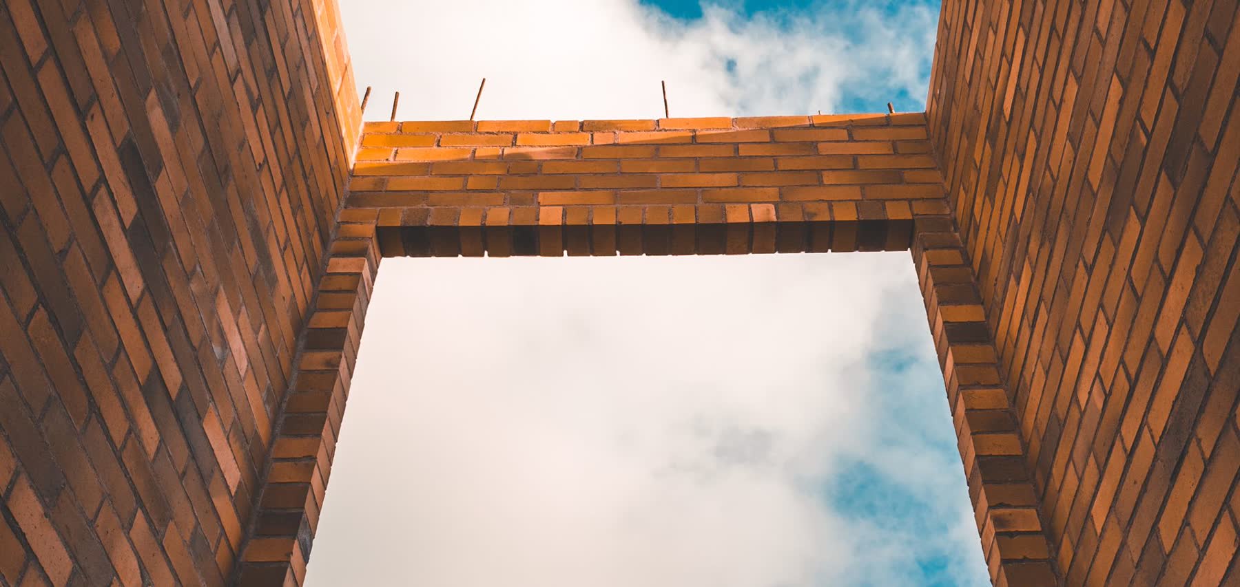 Unfinished brick walls of a new home extension against the sky